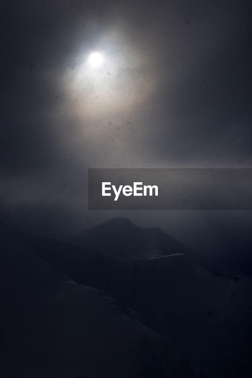 moon, moonlight, sky, beauty in nature, darkness, scenics - nature, mountain, night, nature, fog, cloud, no people, tranquility, astronomical object, tranquil scene, environment, full moon, landscape, light, dark, silhouette, outdoors, mountain range, non-urban scene, horizon