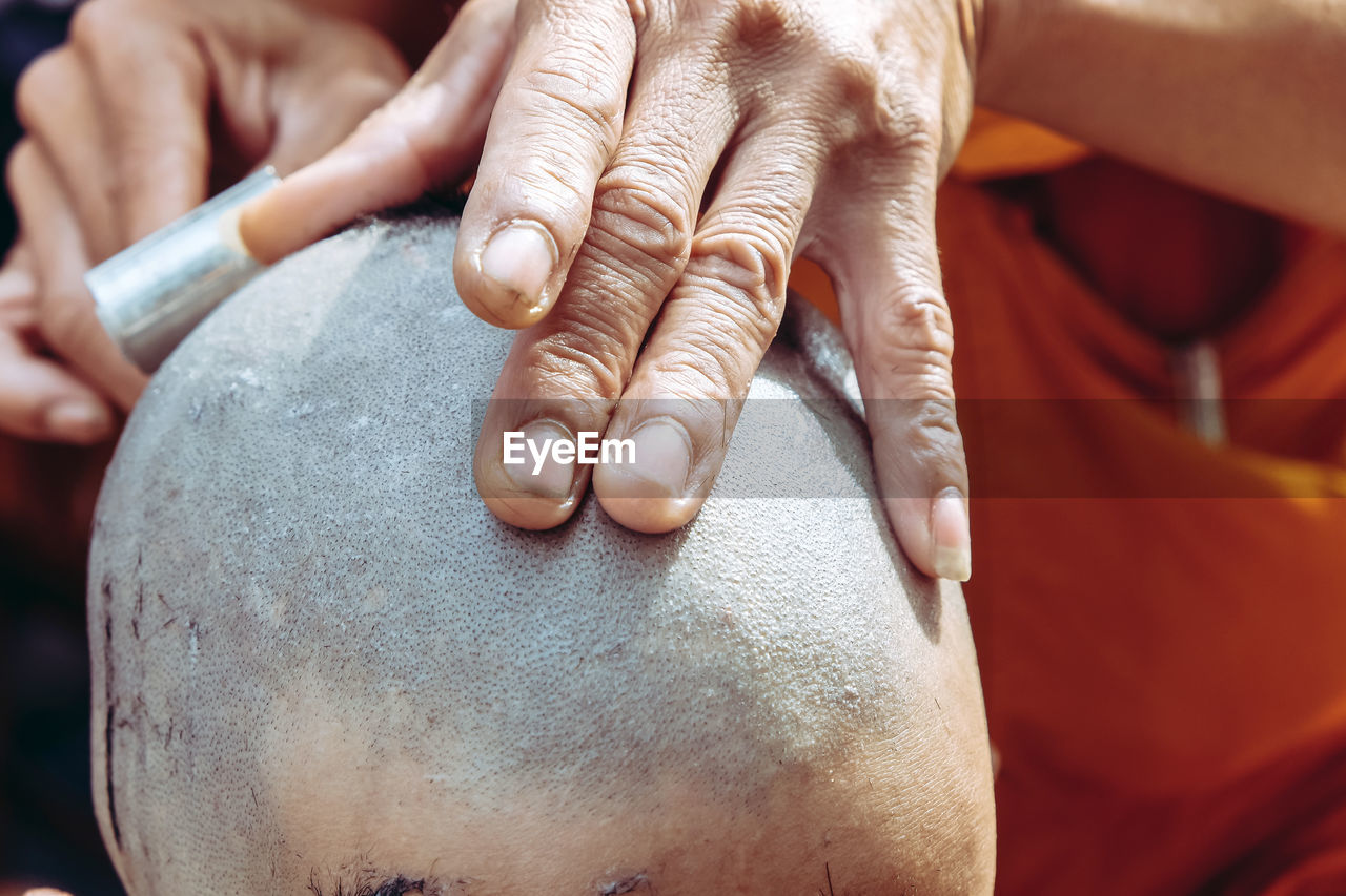 Close-up of man shaving head of boy