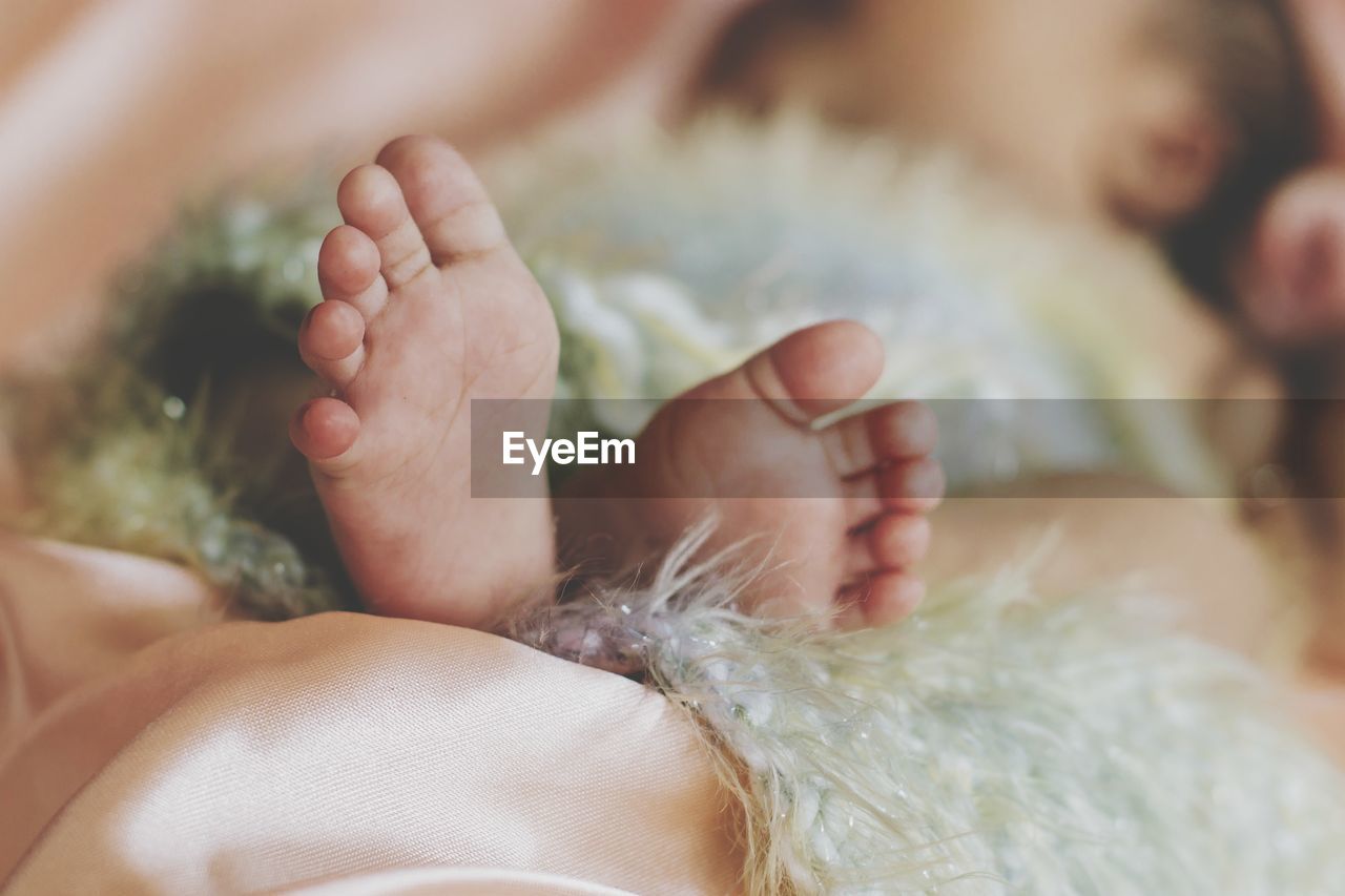 Close-up of baby feet on bed