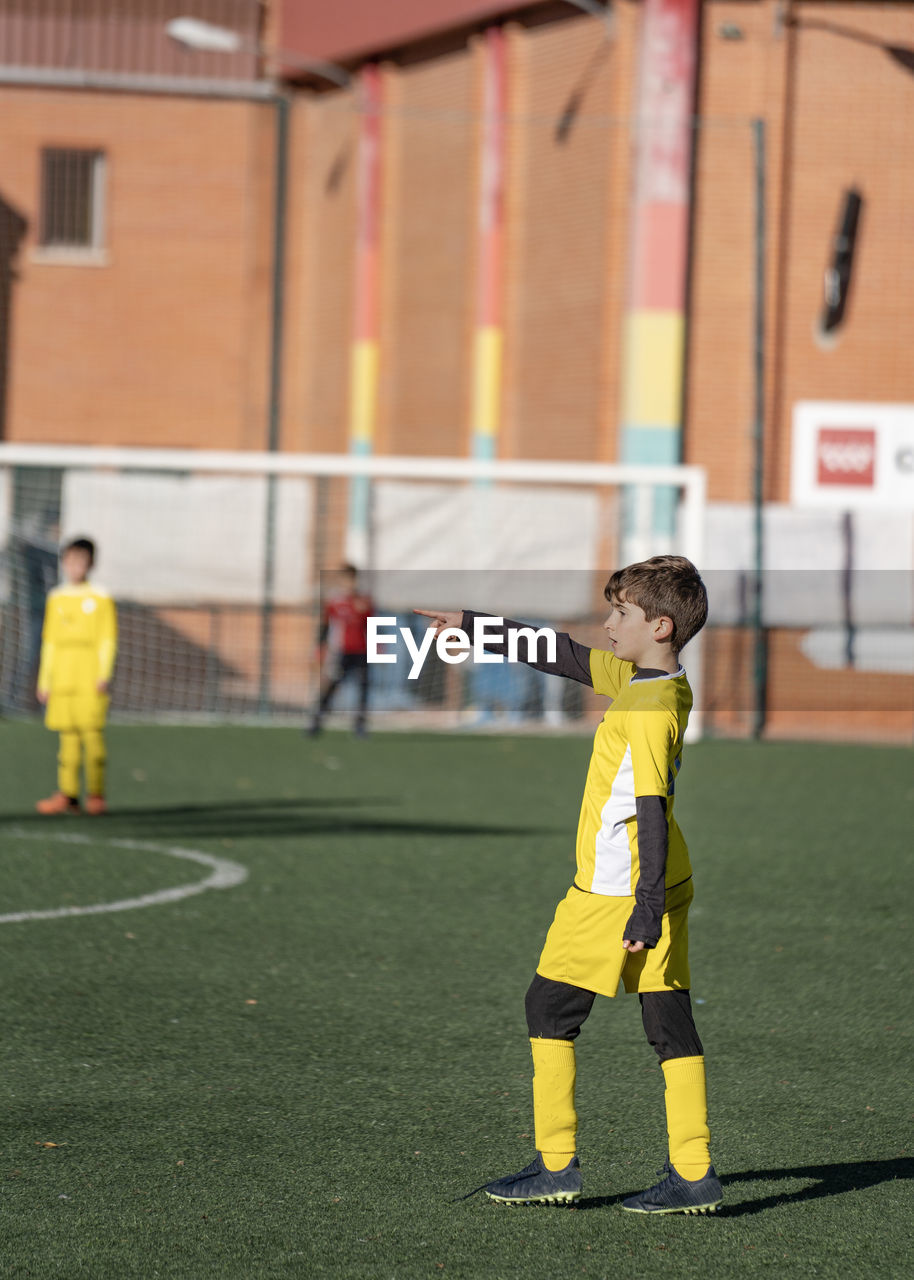 Kid football player giving directions to his team in a soccer match.