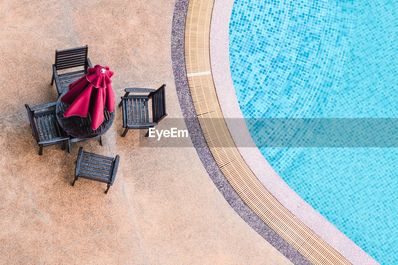 High angle view of chair by swimming pool