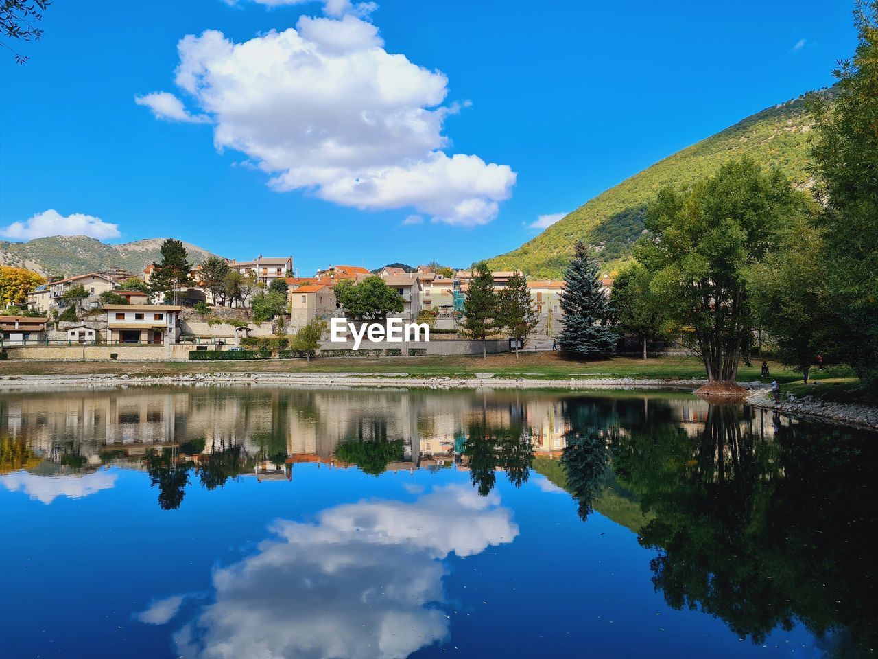 SCENIC VIEW OF LAKE BY BUILDINGS AGAINST SKY