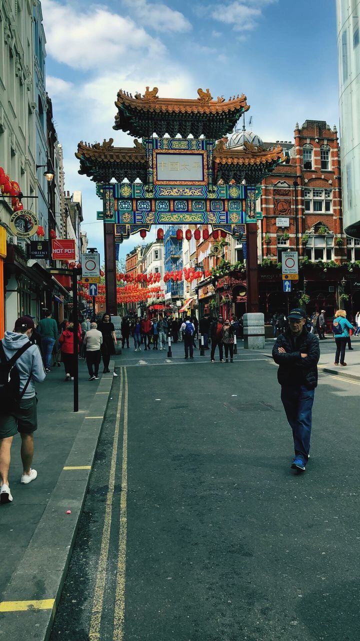 GROUP OF PEOPLE WALKING ON STREET IN CITY