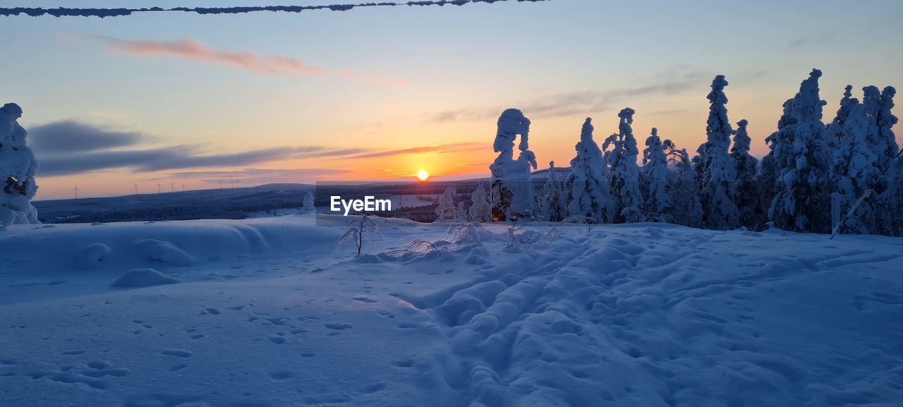 SNOW COVERED LAND DURING SUNSET