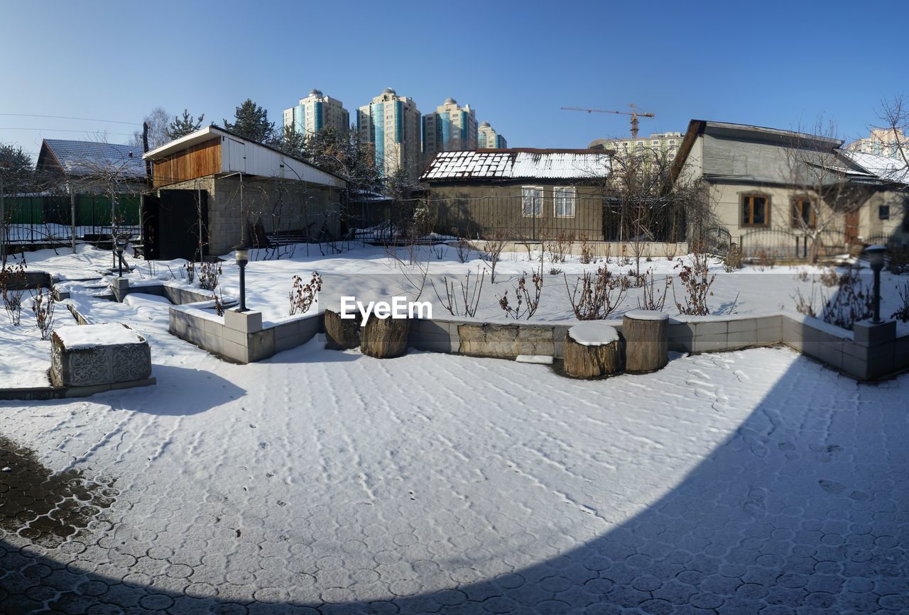 SNOW COVERED BUILDINGS AGAINST CLEAR SKY