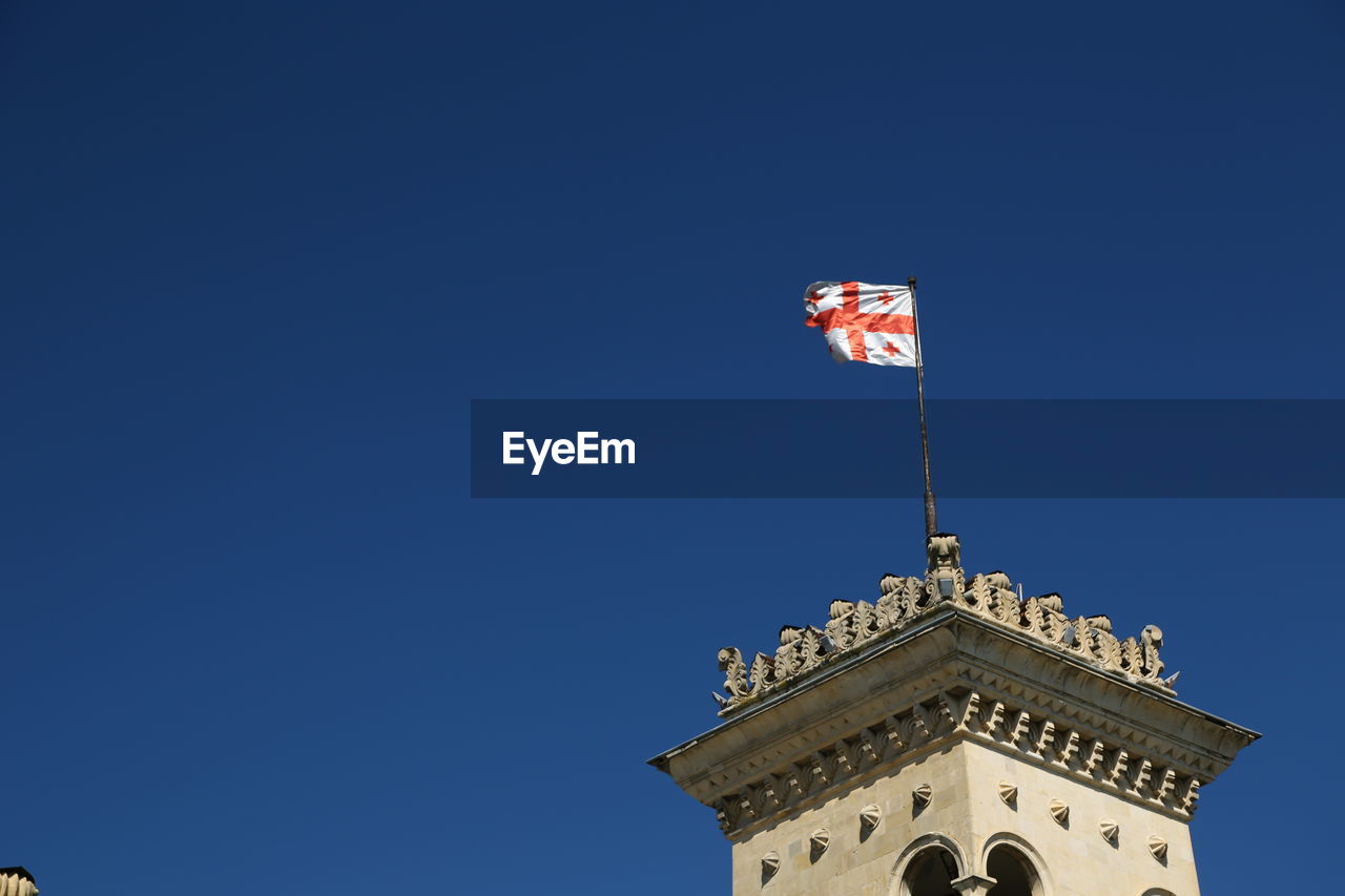 LOW ANGLE VIEW OF FLAG AGAINST BUILDING