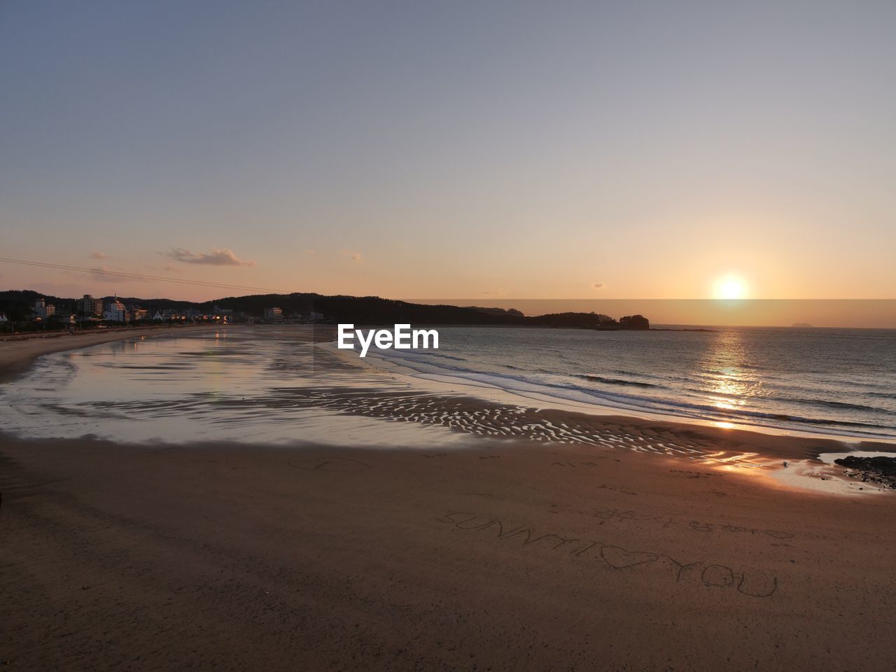 SCENIC VIEW OF BEACH AT SUNSET