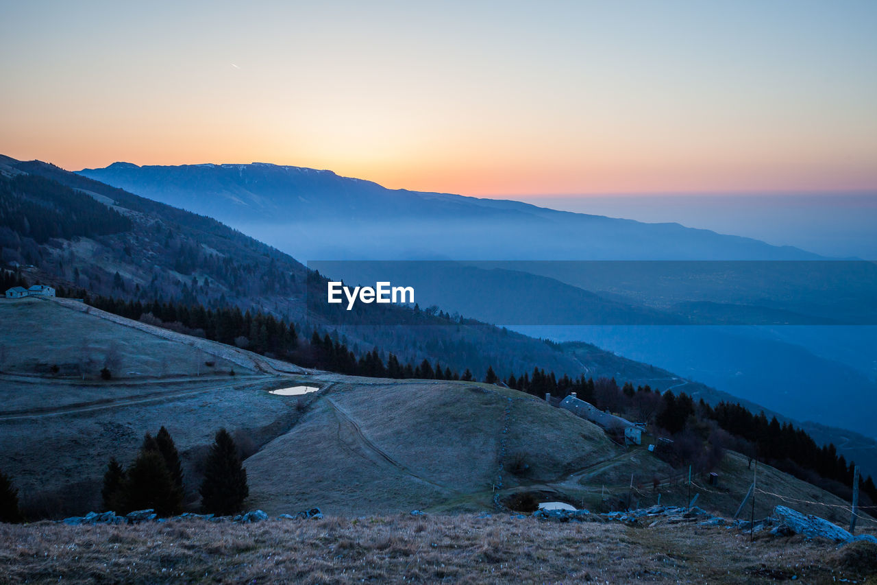 Scenic view of snowcapped mountains against sky during sunset