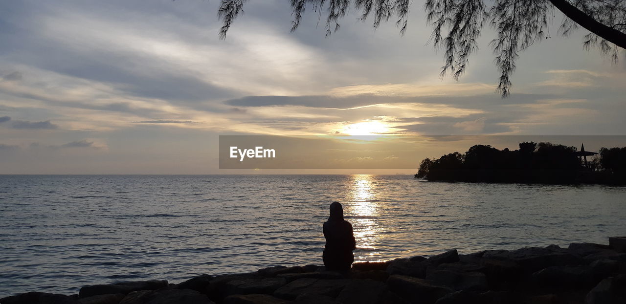 SILHOUETTE OF PEOPLE LOOKING AT SEA AGAINST SKY