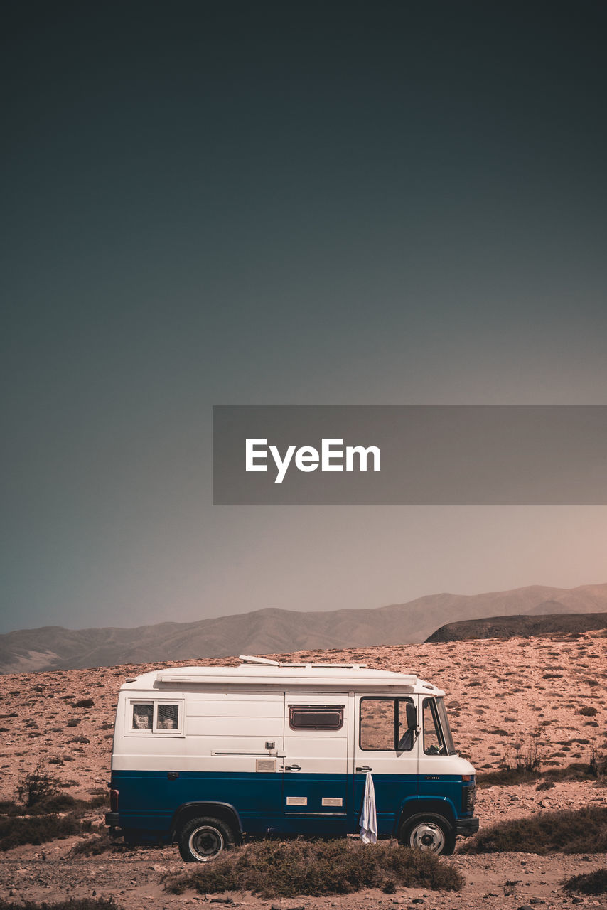 VINTAGE CAR ON DESERT LAND