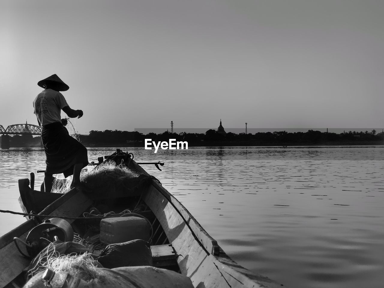 PEOPLE SITTING IN LAKE AGAINST SKY