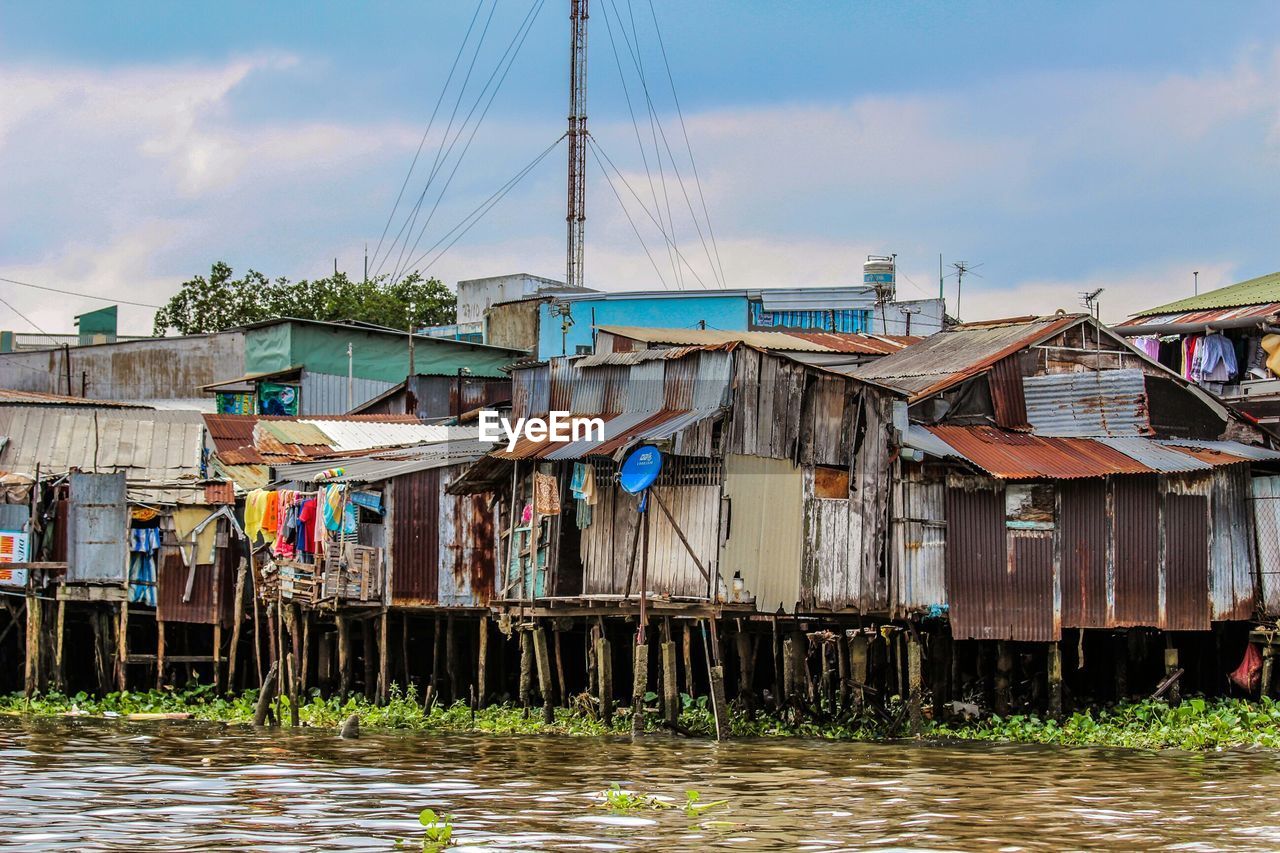 Stilt houses over mekong river against sky