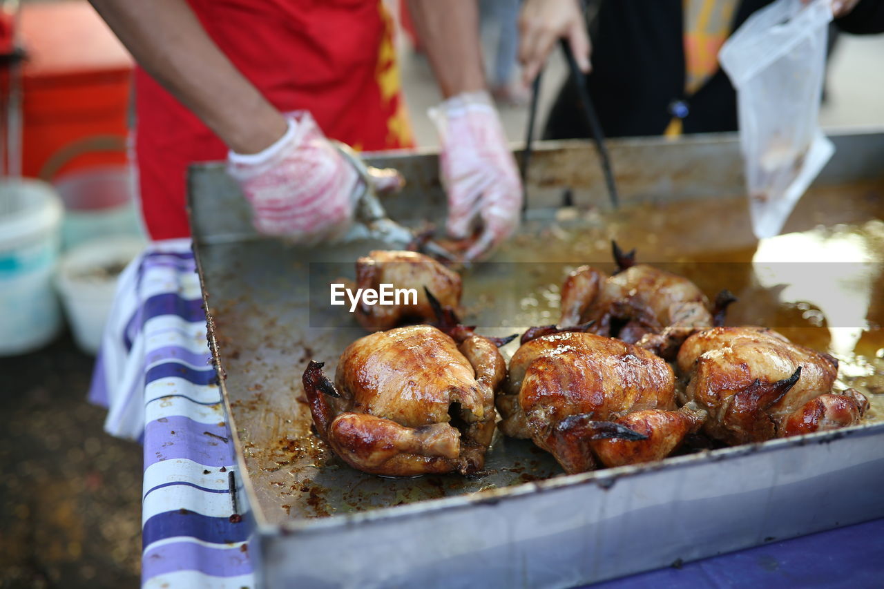 Midsection of man preparing chicken