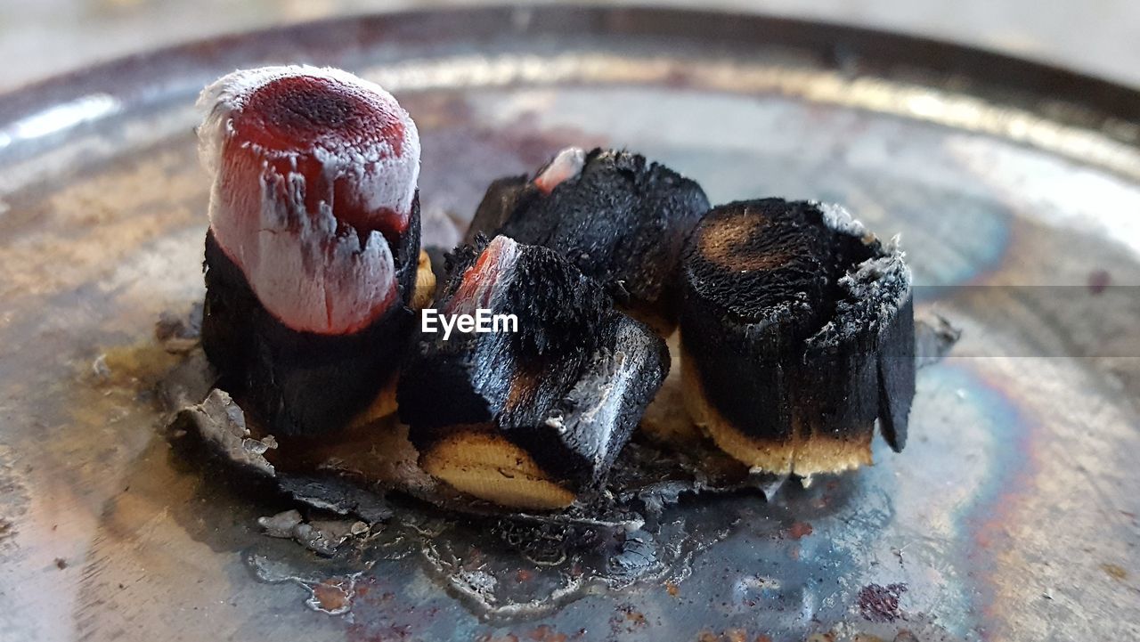 Close-up of burning coals on plate