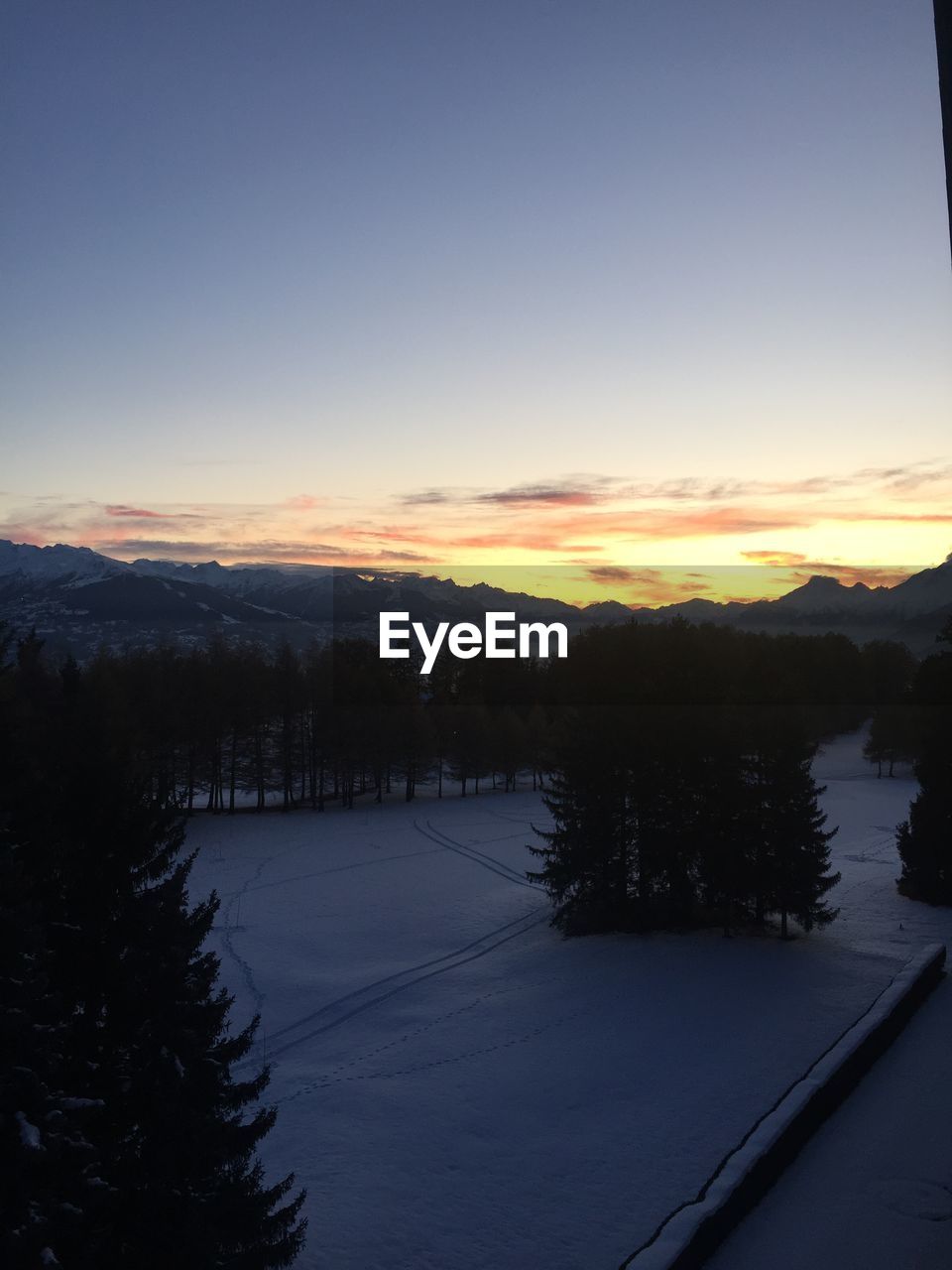 SCENIC VIEW OF SNOW COVERED LANDSCAPE AGAINST SKY DURING SUNSET