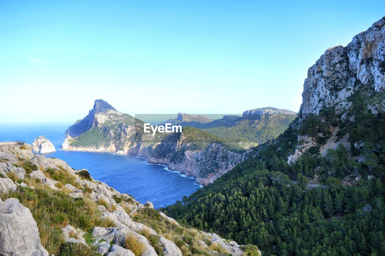 Panoramic view of sea and mountains against clear blue sky