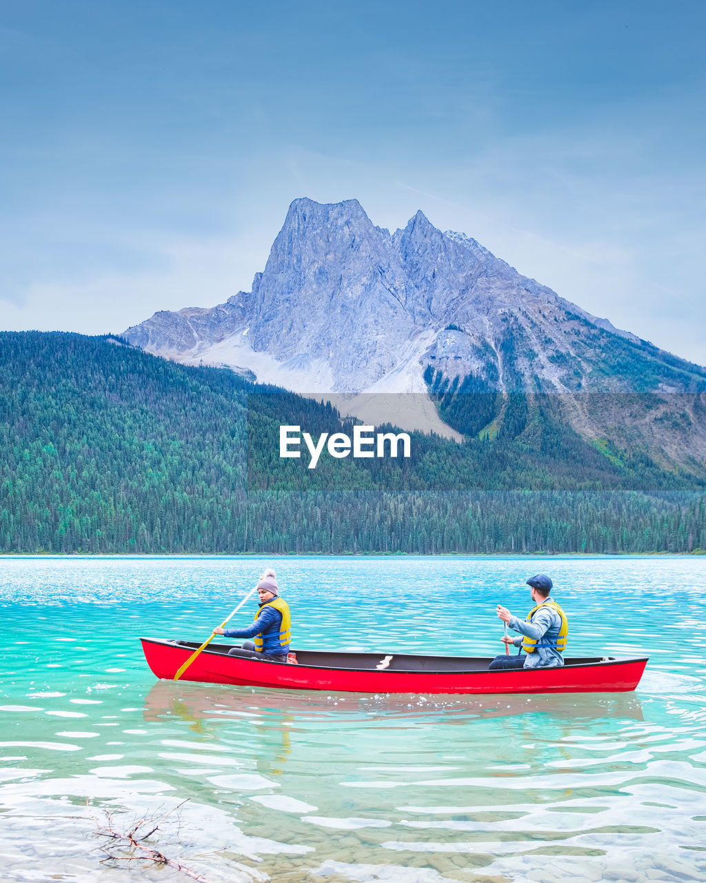 PEOPLE ON BOAT IN LAKE AGAINST SKY