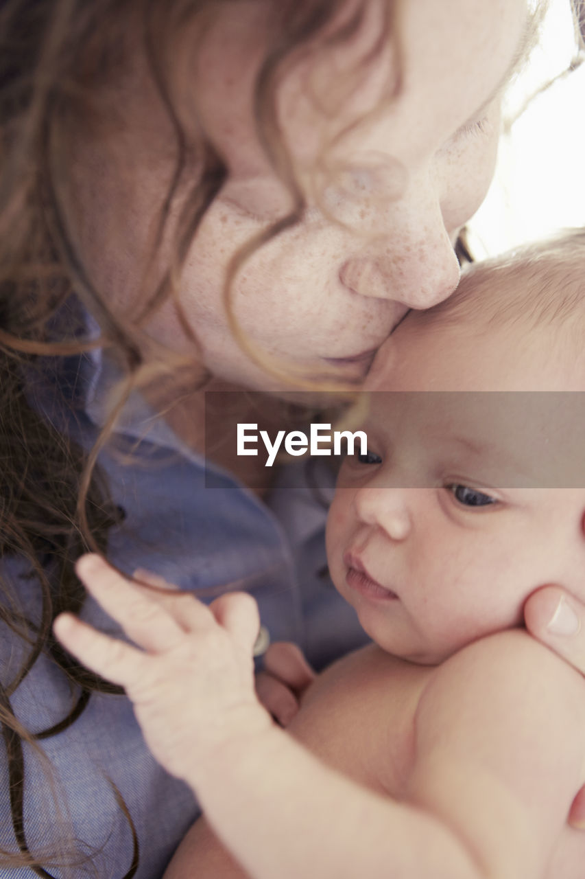 Mother kissing babies forehead