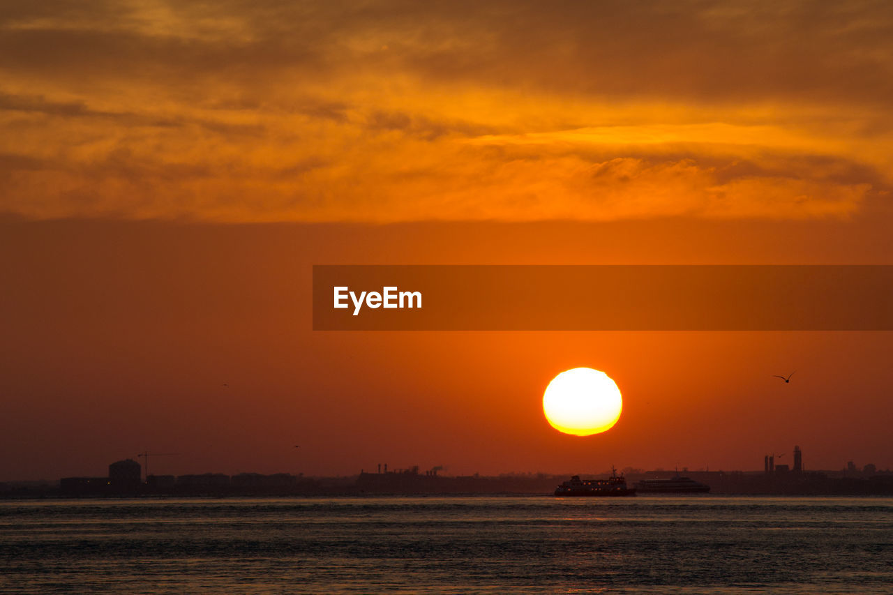 Scenic view of sea against orange sky