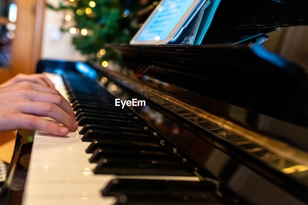 Cropped hands of person playing piano