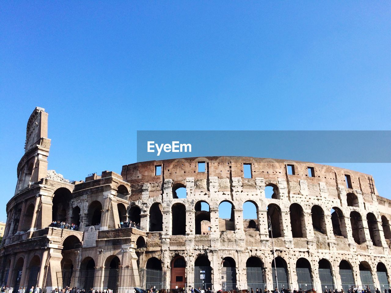 Low angle view of colosseum against clear blue sky