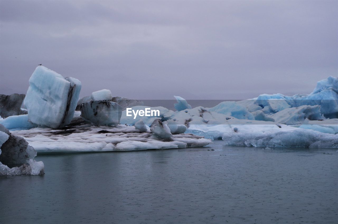 FROZEN LAKE AGAINST SKY IN WINTER