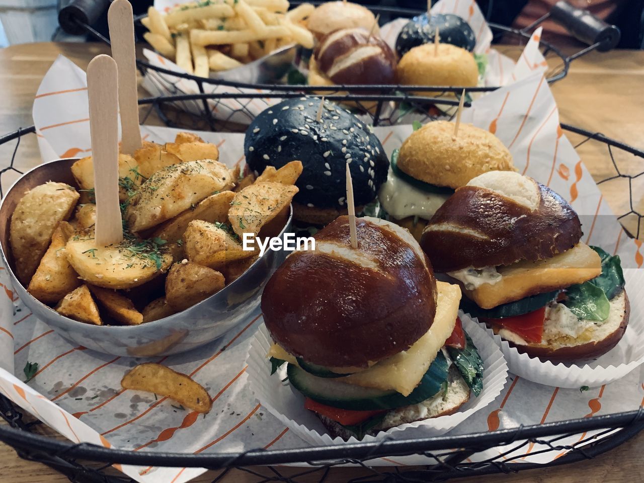 HIGH ANGLE VIEW OF BURGER AND VEGETABLES ON TABLE