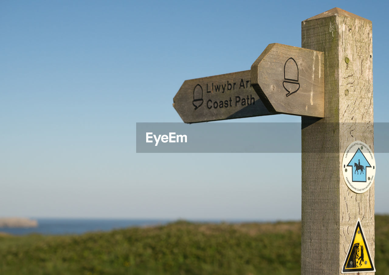 Close-up of road sign against clear sky