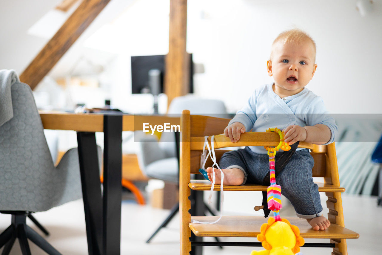 portrait of boy playing with toy blocks while sitting on table