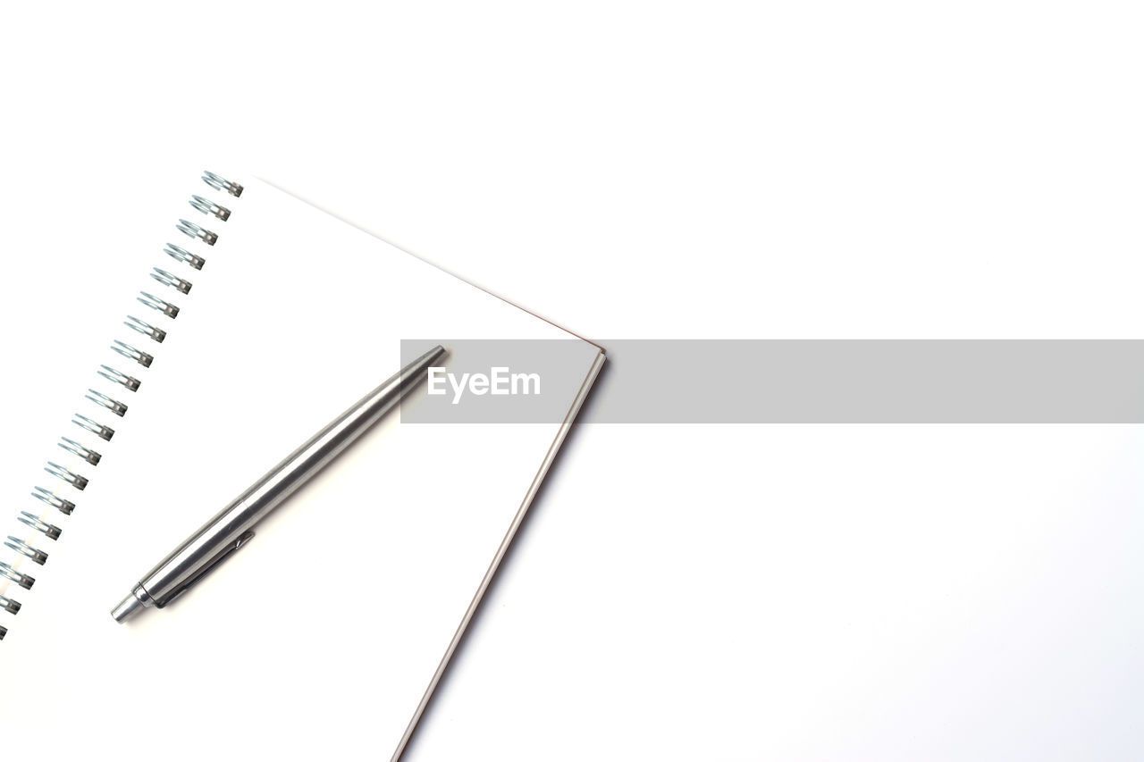 High angle view of book with pen on white background