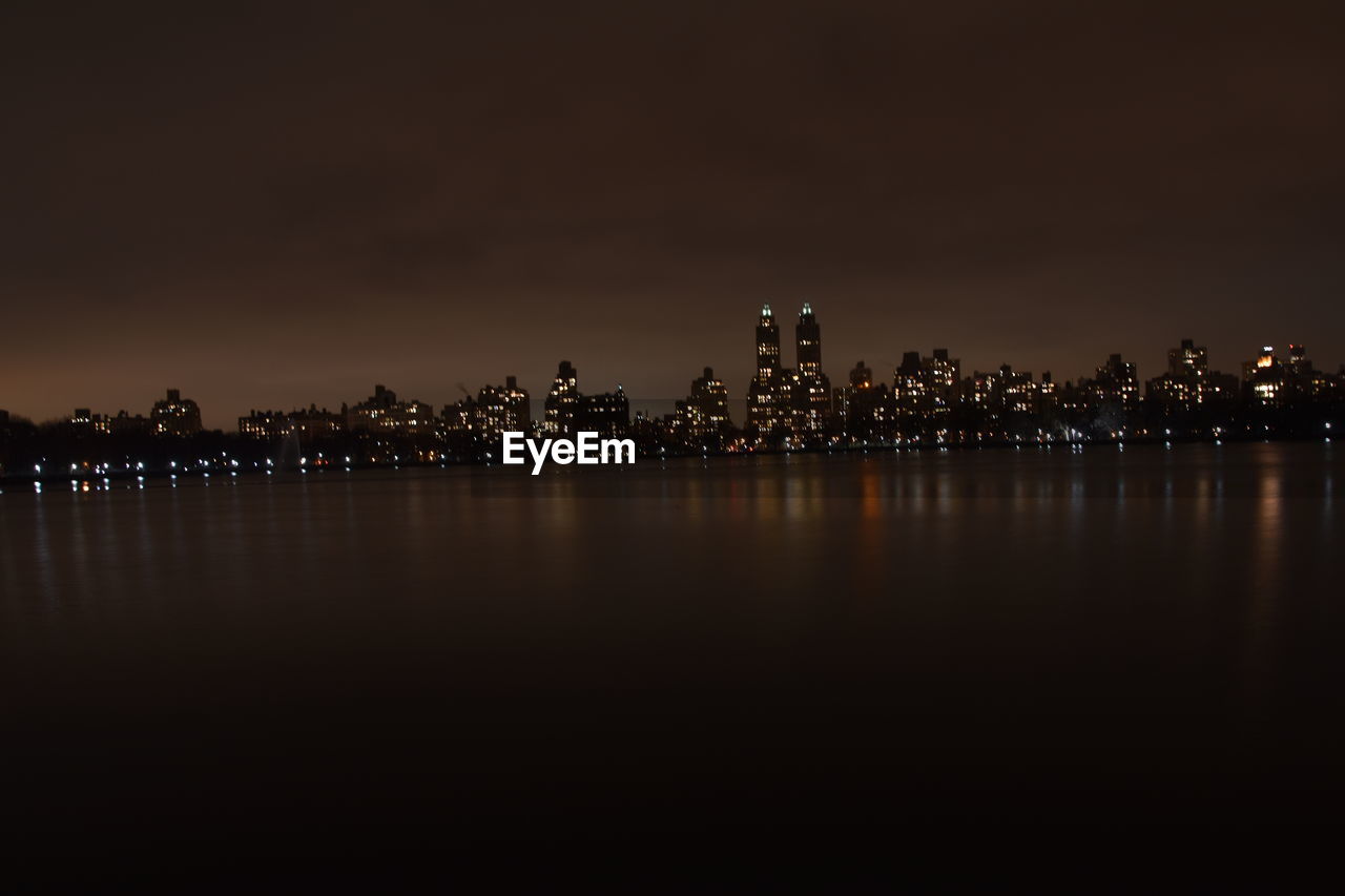 Illuminated city at waterfront at night