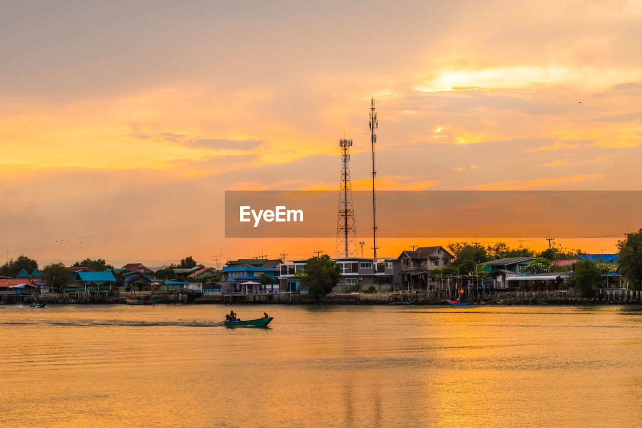 NAUTICAL VESSEL ON RIVER AGAINST SKY DURING SUNSET