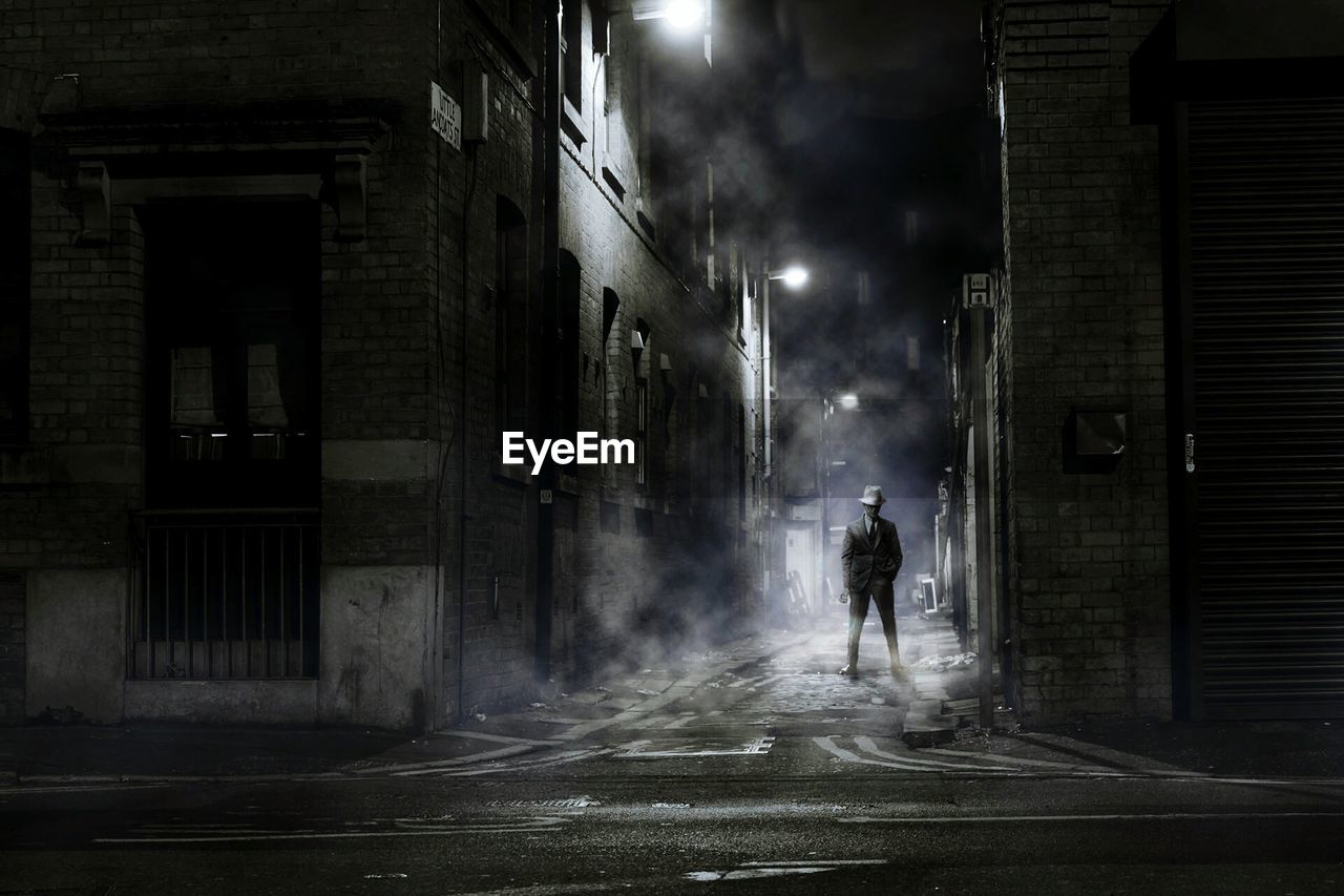 Man standing on street at night