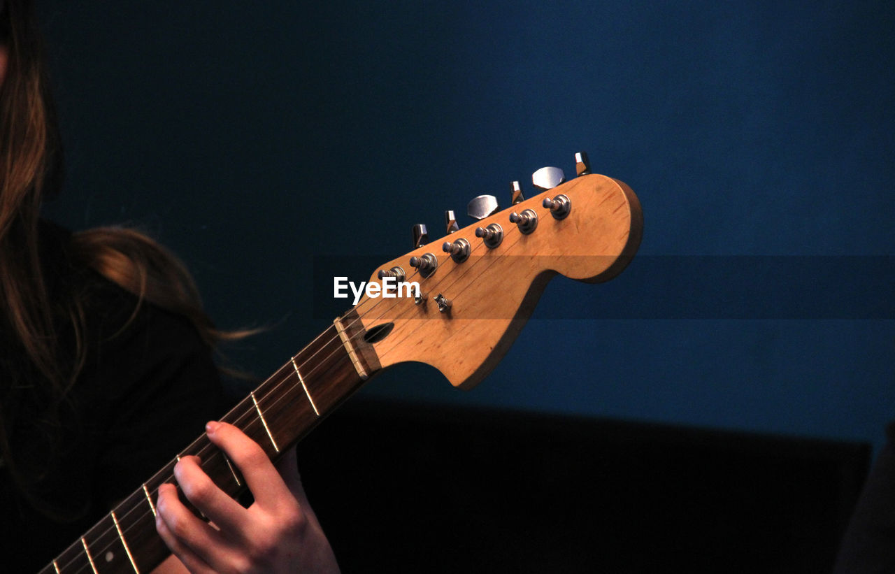 Cropped hand of woman playing guitar