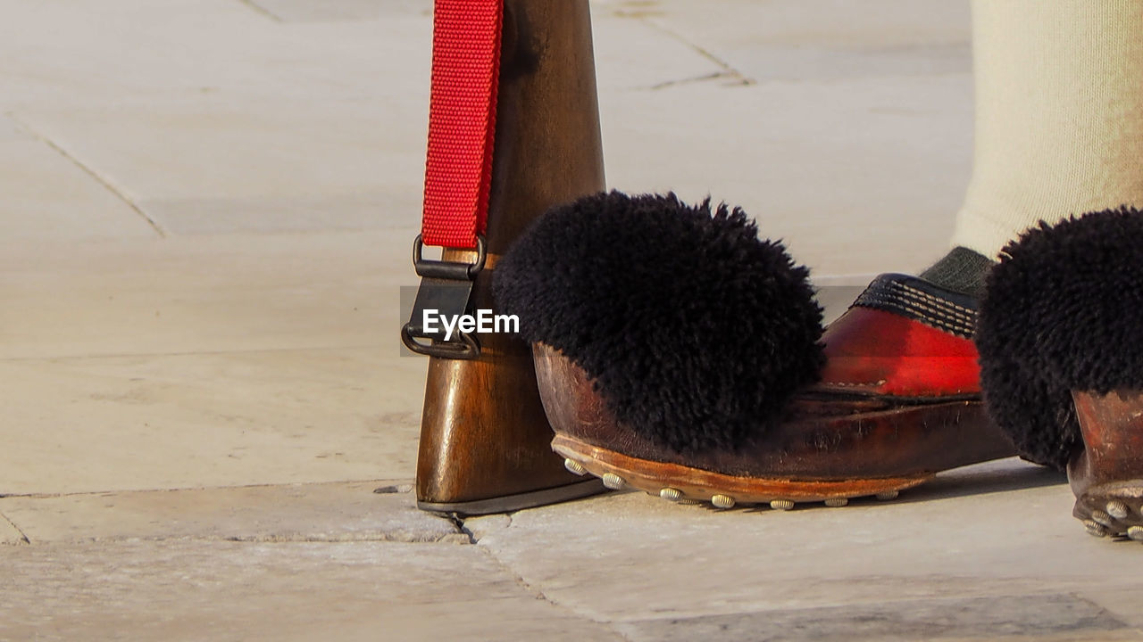 Close-up of footwear and weapon on floor