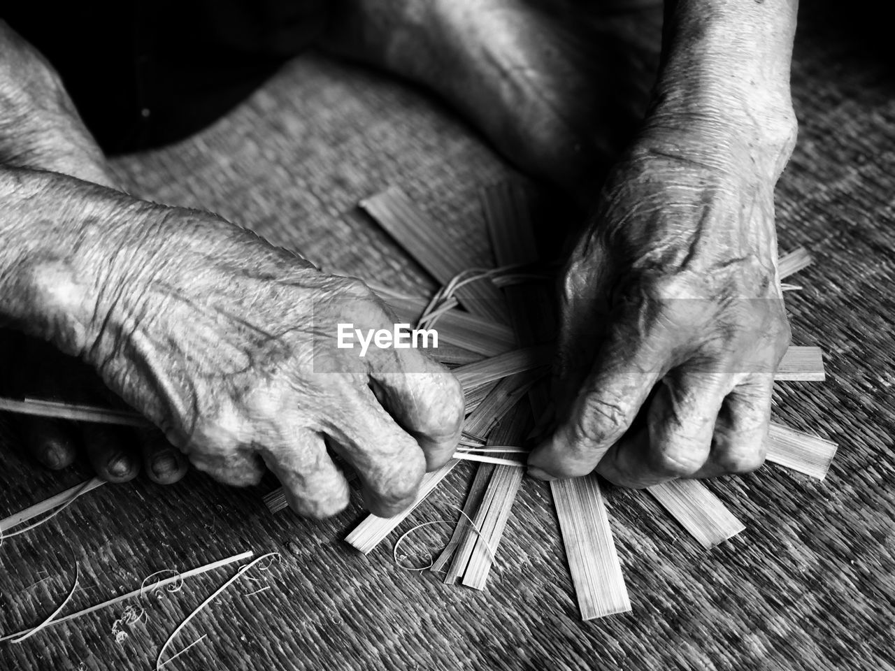 MIDSECTION OF MAN WORKING ON WOODEN TABLE