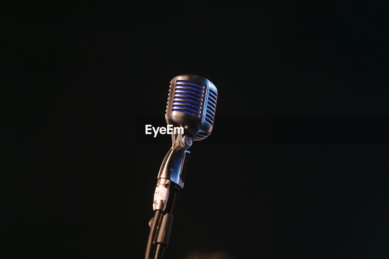 Close-up of microphone against black background