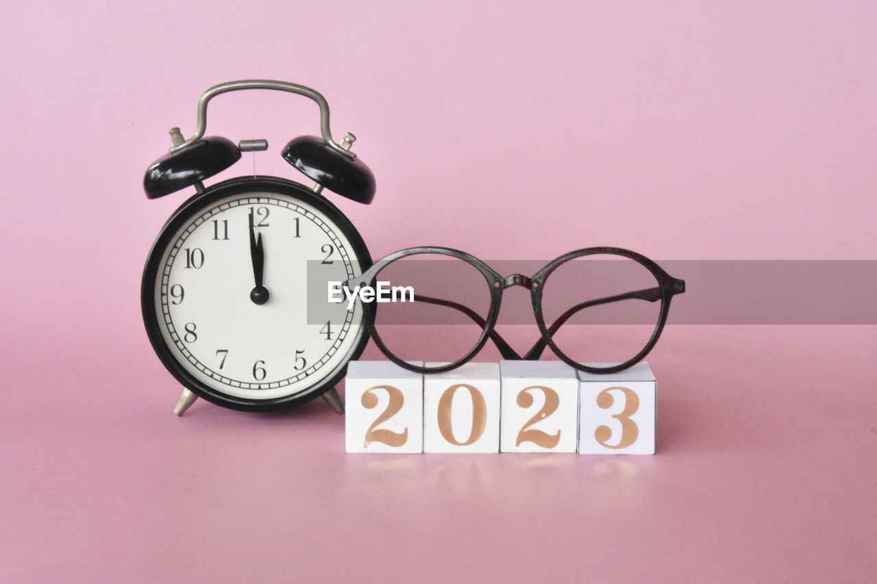 clock, time, alarm clock, pink, number, studio shot, font, indoors, no people, clock face, colored background, pink background, minute hand, deadline, instrument of time, still life, eyeglasses