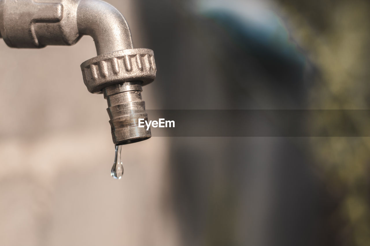 Close-up of water drop falling from faucet