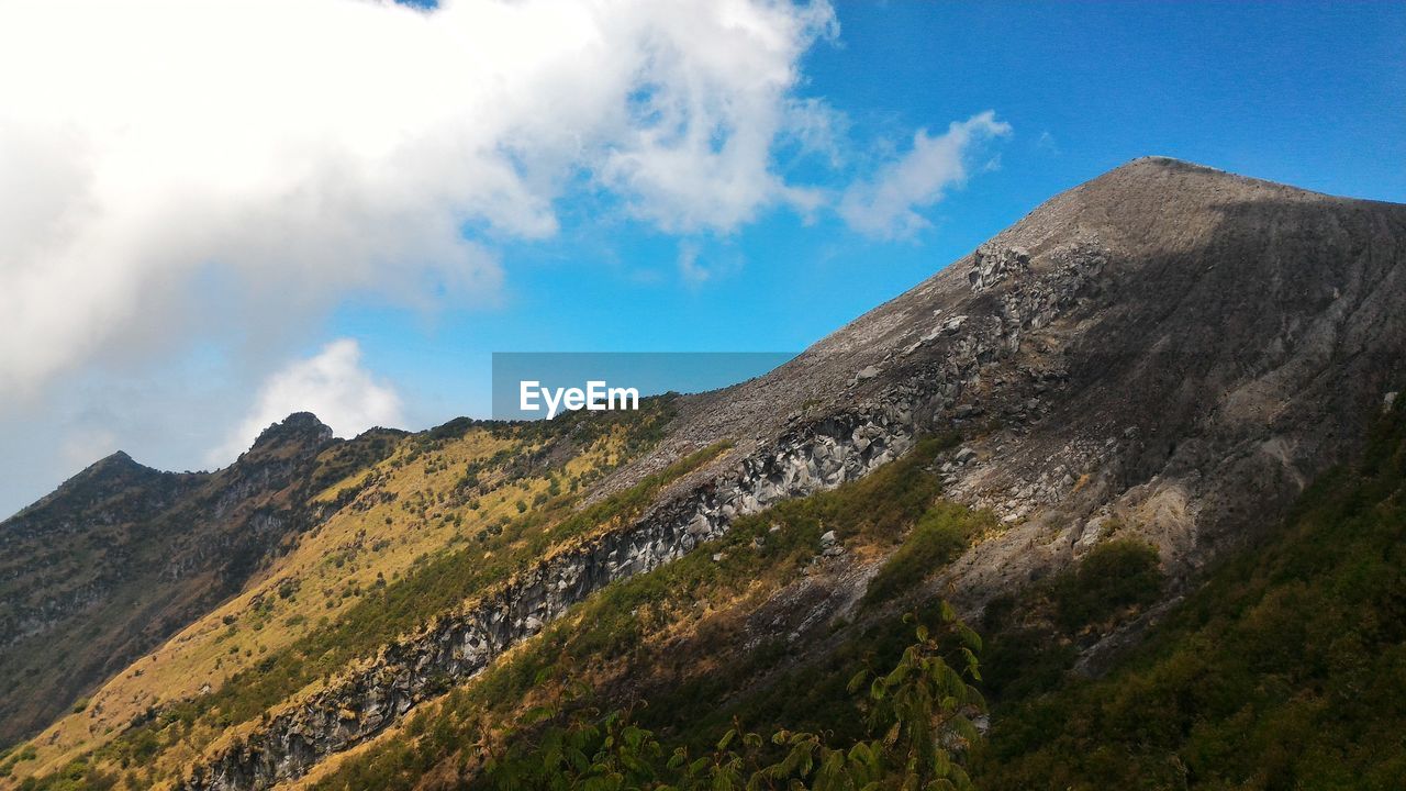 LOW ANGLE VIEW OF PANORAMIC SHOT OF MOUNTAIN RANGE AGAINST SKY