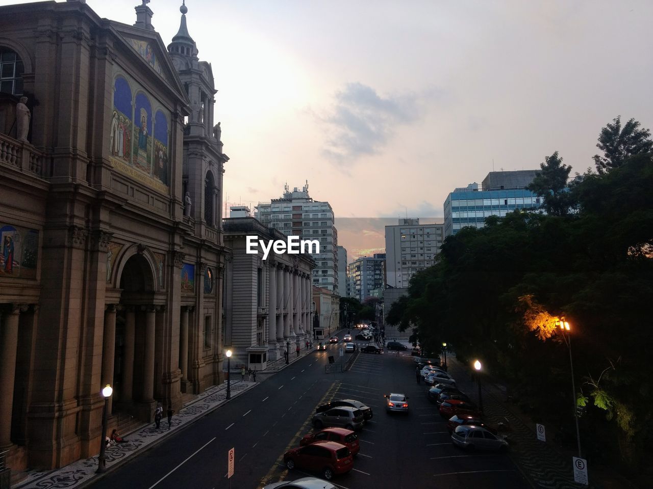 CITY STREET AMIDST BUILDINGS AGAINST SKY AT DUSK