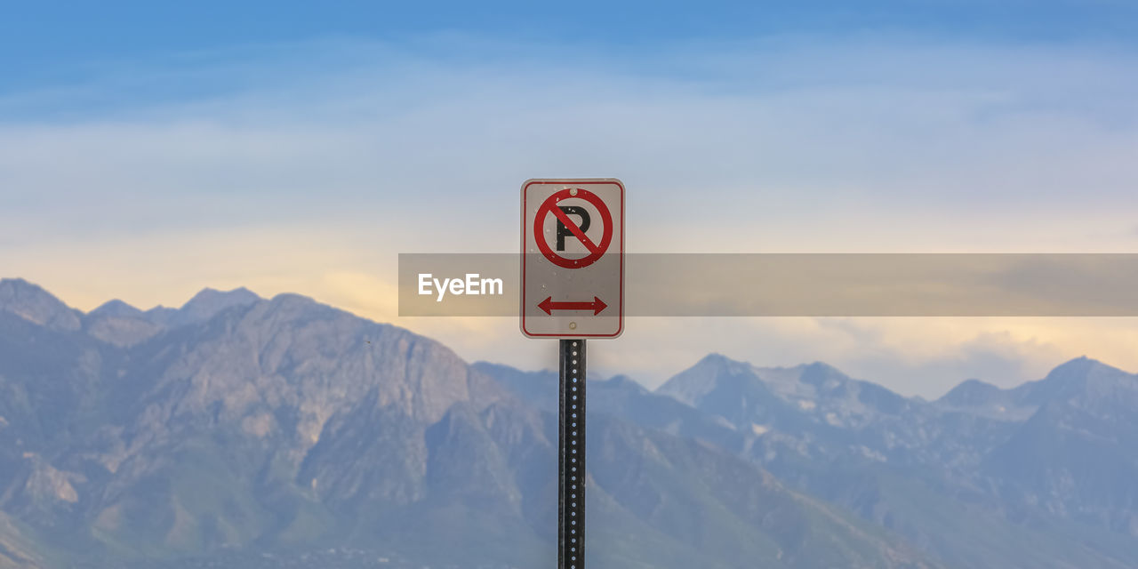 INFORMATION SIGN AGAINST SNOWCAPPED MOUNTAINS