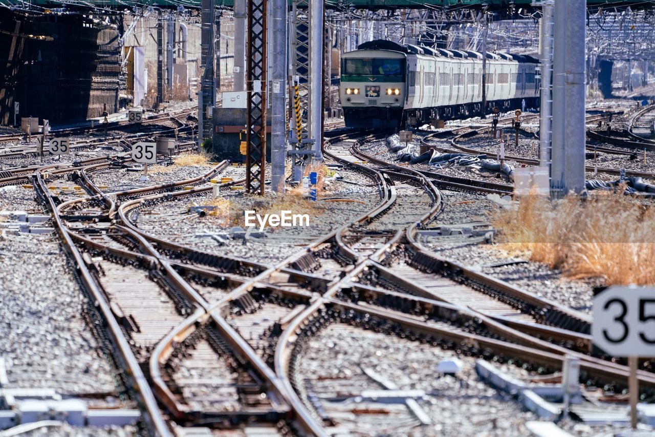 HIGH ANGLE VIEW OF RAILROAD TRACKS ALONG ROAD