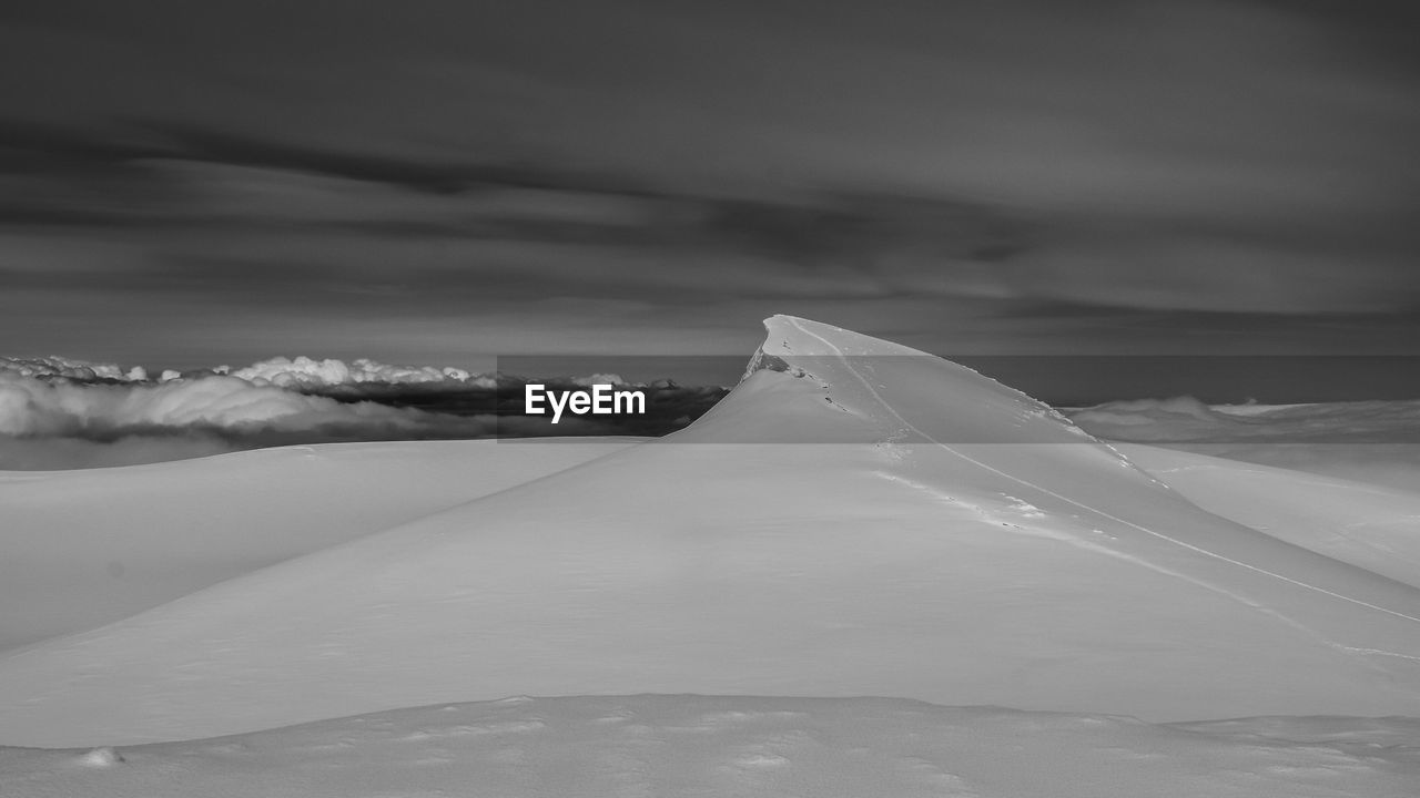 CLOSE-UP OF SNOW CAPPED MOUNTAIN AGAINST SKY