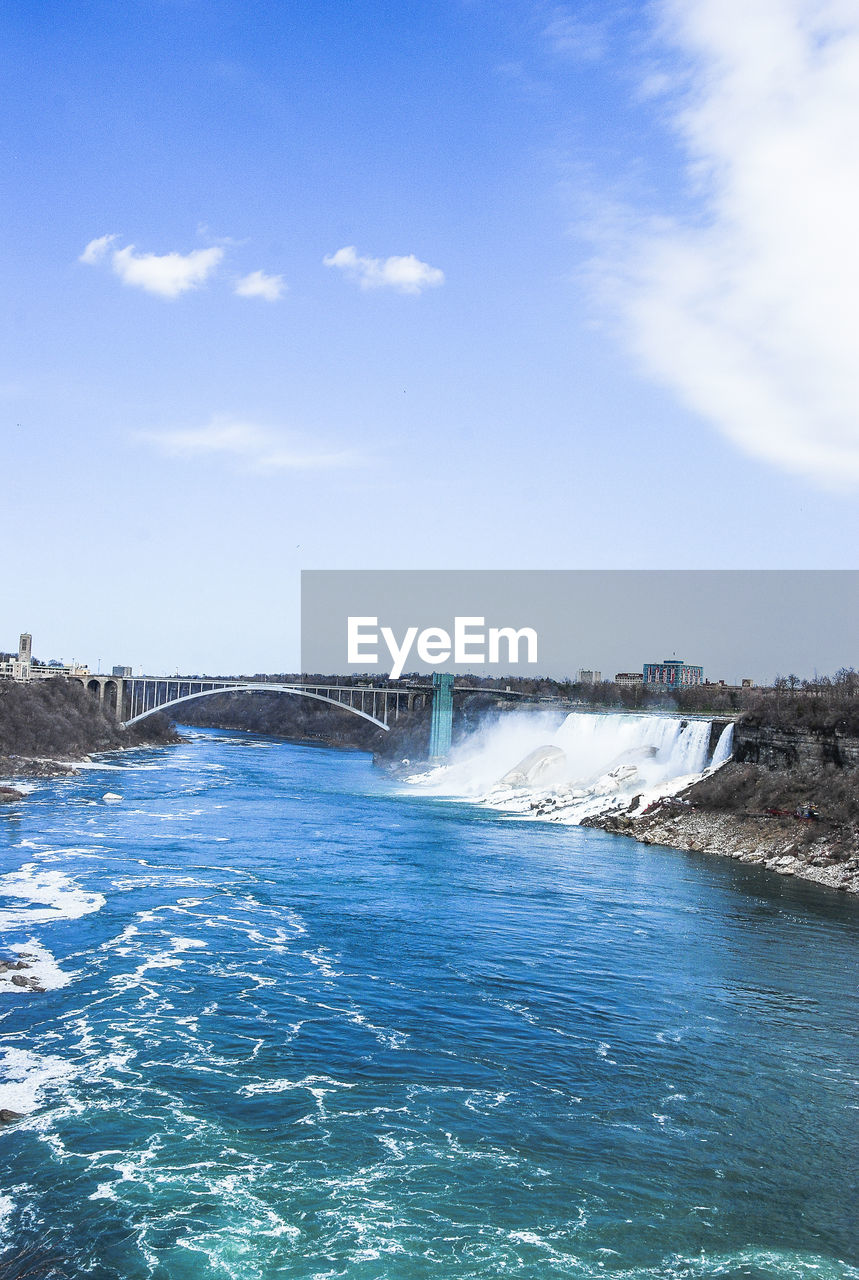 SCENIC VIEW OF WATERFALL AGAINST BLUE SKY