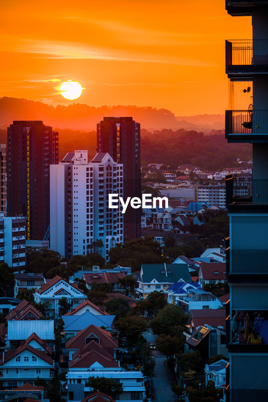 Illuminated buildings against sky during sunset