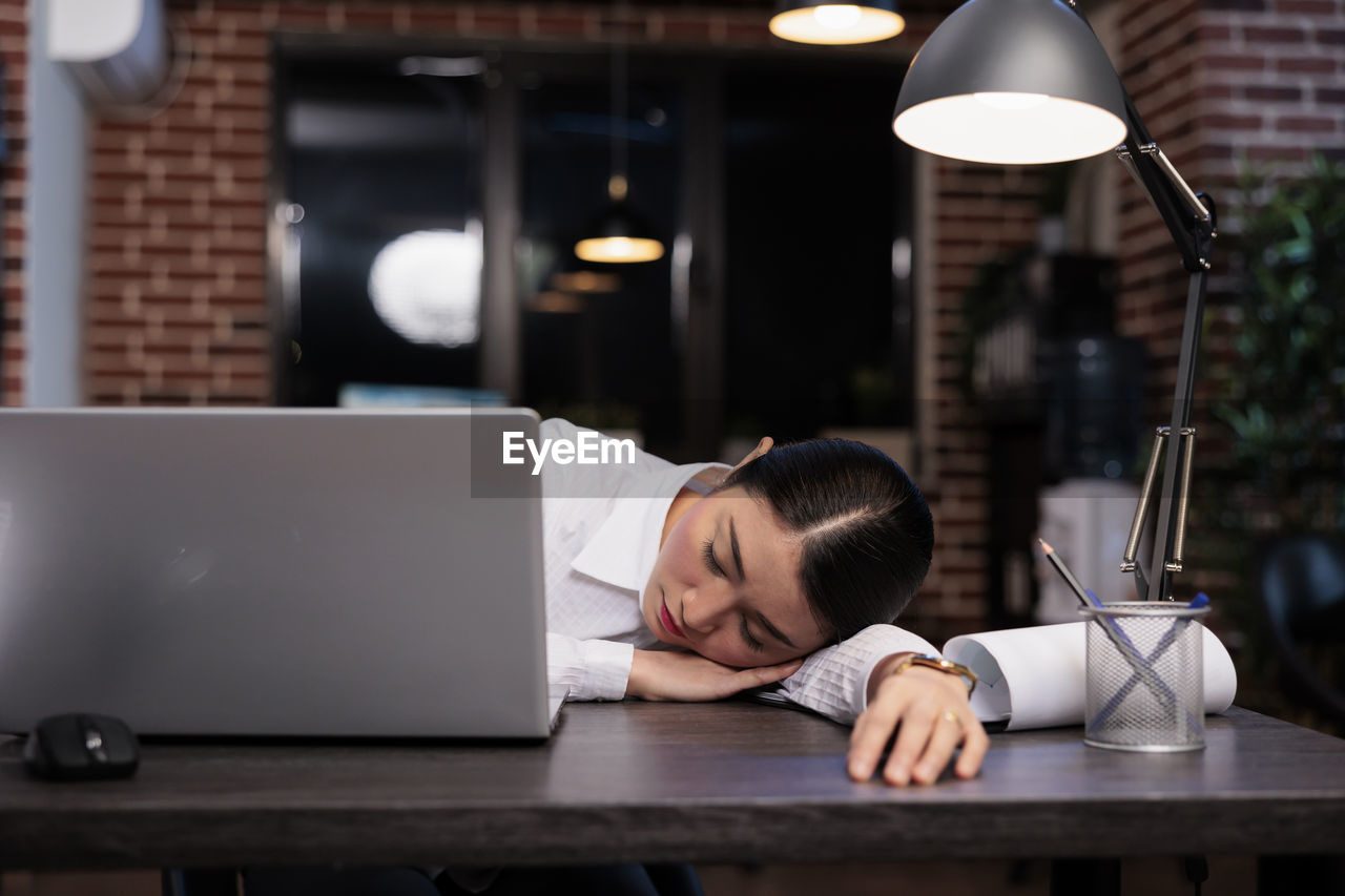 Overworked businesswoman resting on table