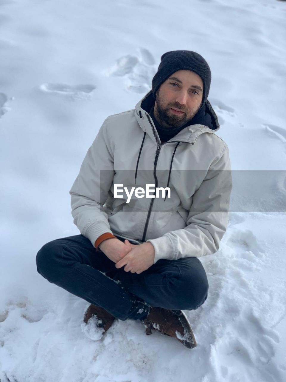 Young man sitting in snow