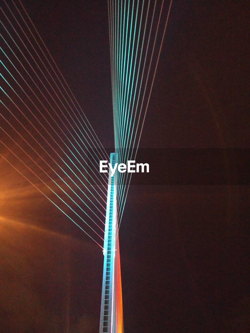 LOW ANGLE VIEW OF ILLUMINATED SUSPENSION BRIDGE AGAINST SKY