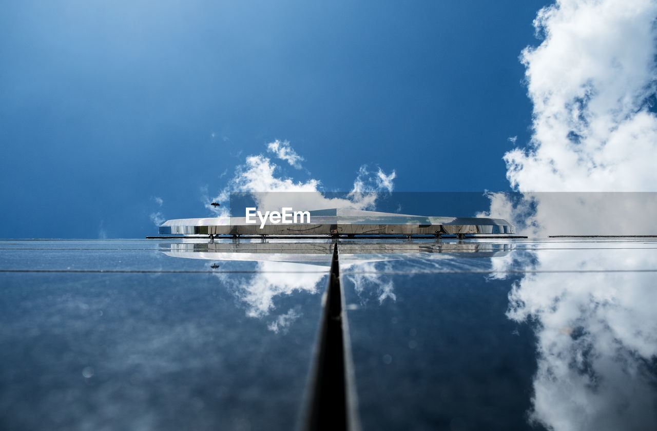 Glass building with reflection of clouds and sky on it